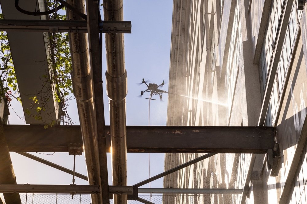 Drone schoonmaak bij industriële gevel met installaties