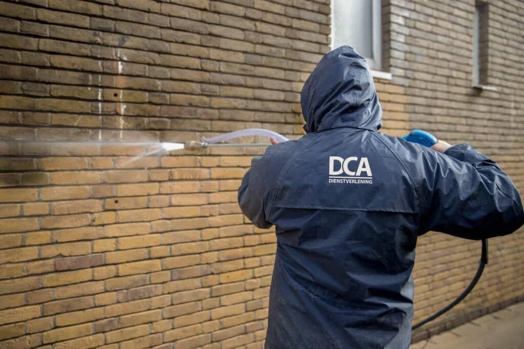 Zandstralen bij gevelreiniging en harde vervuiling op buitenmuur